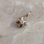 Gold pendant with a diamond on a marble surface