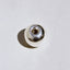 Close-up of a silver metal object on a beige background
