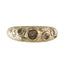 A textured gold ring featuring multiple organic-shaped dark brown and black inclusions, shown against a plain white background.